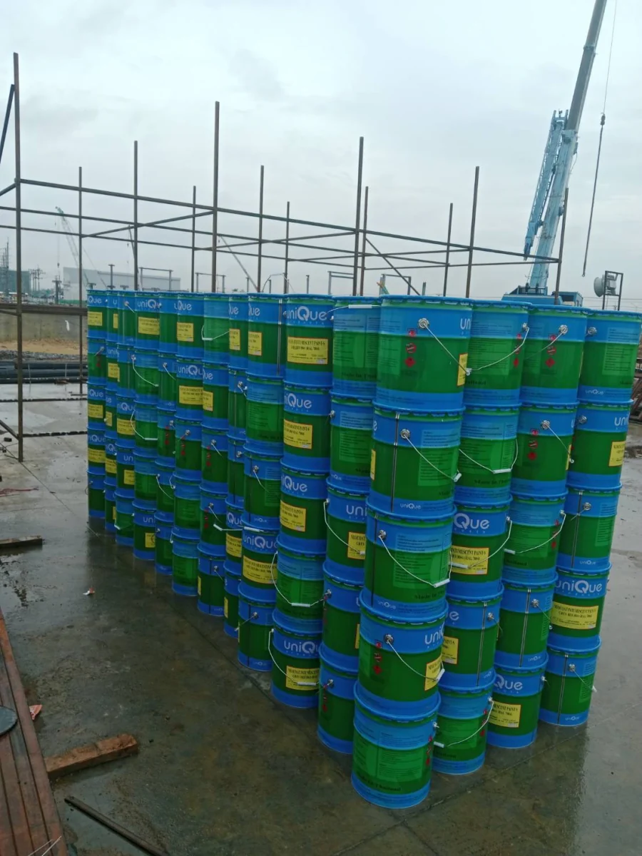 ถังสีกันไฟ Neocoat Intumescent Paint-S แบรนด์ uniQue เรียงกองที่หน้างานก่อสร้าง